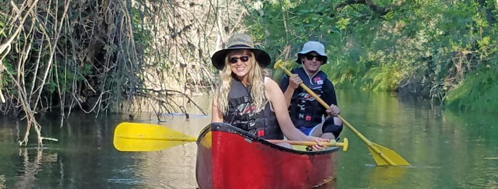 Image of students canoeing down Putah Creek in the Reserve.