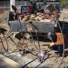person building sculpture out of old shovels